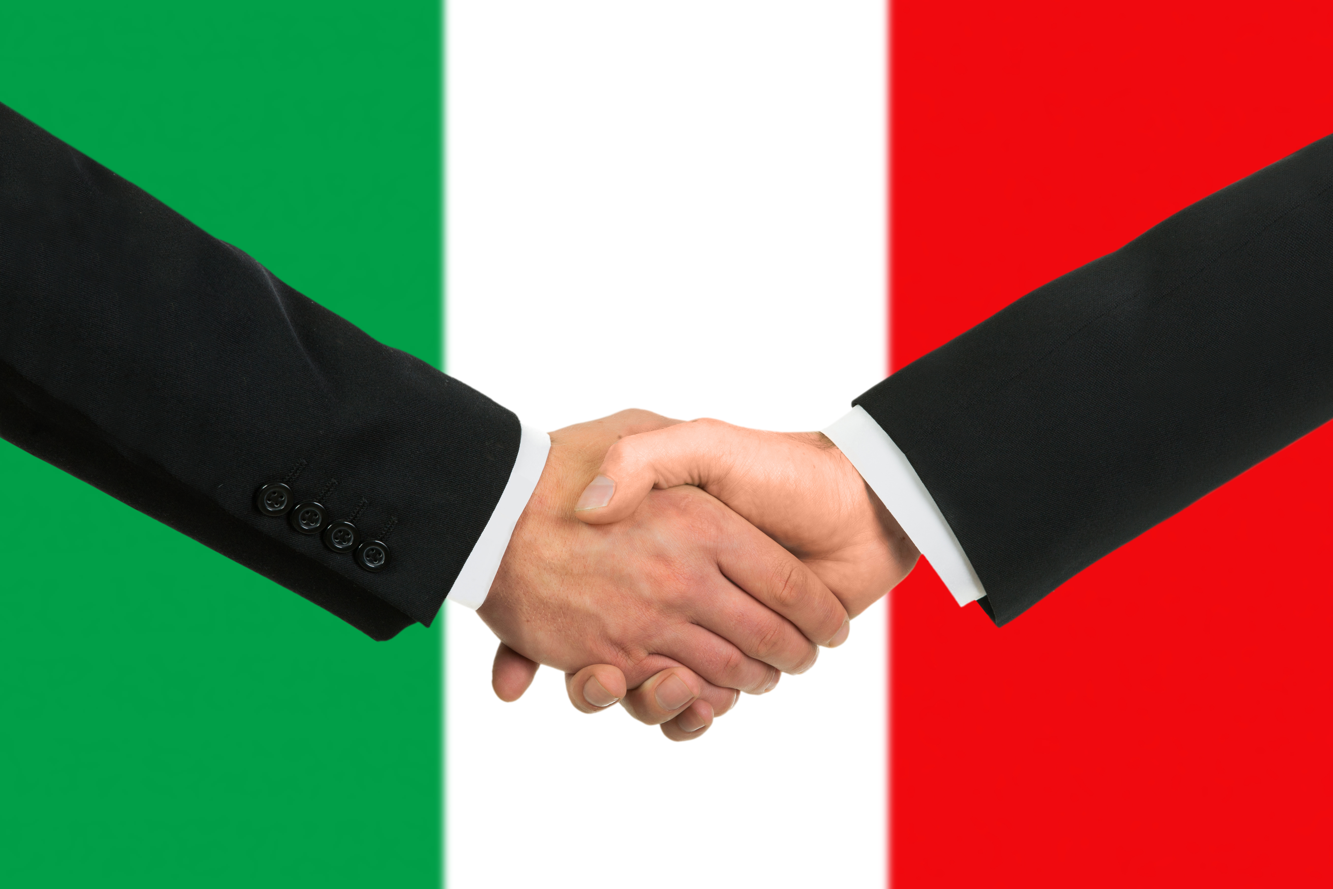 Рукопожатие на фоне флага Италии, куда можно переехать по трудоустройству