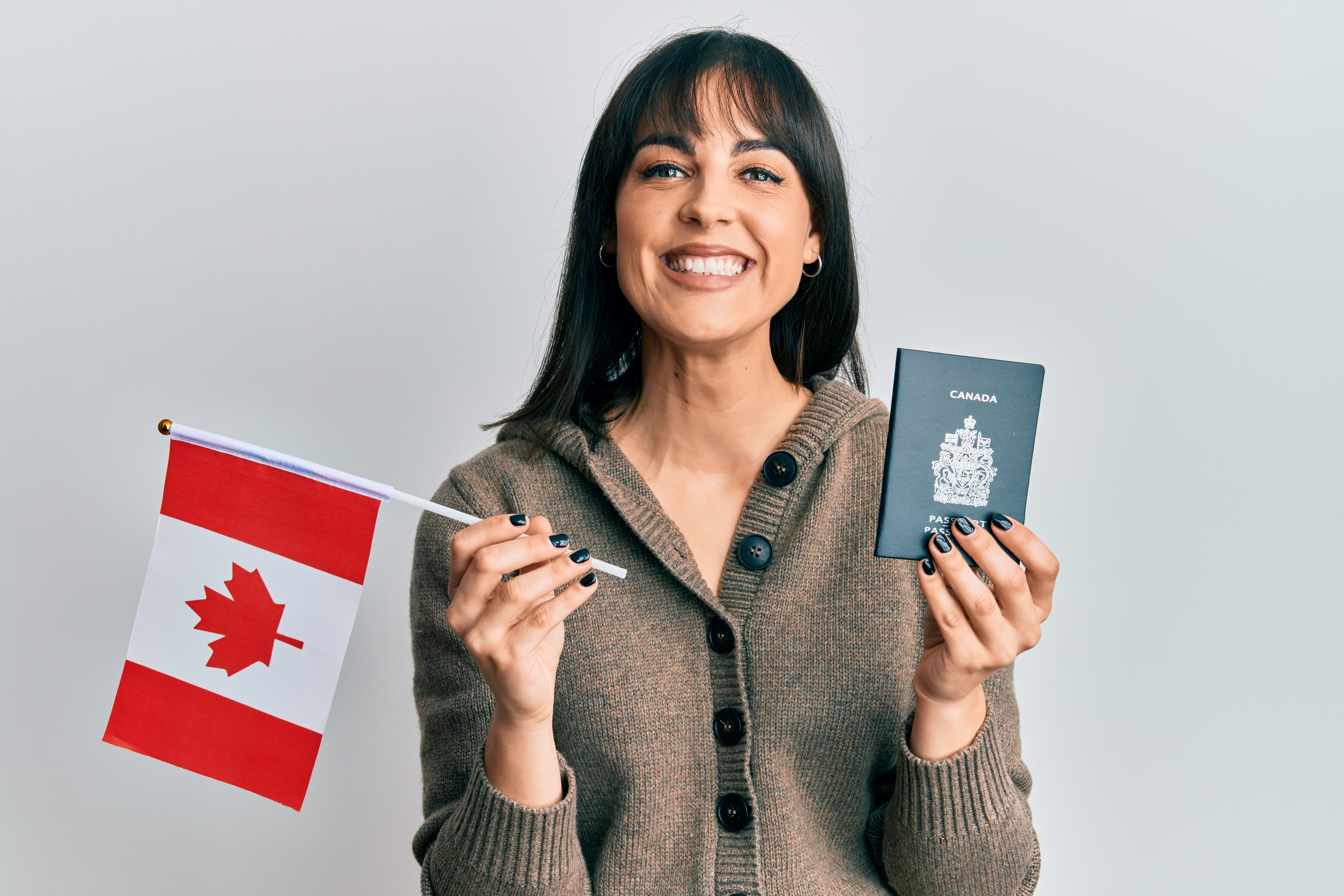 Девушка с флагом и паспортом Канады, гражданам которой доступен безвиз